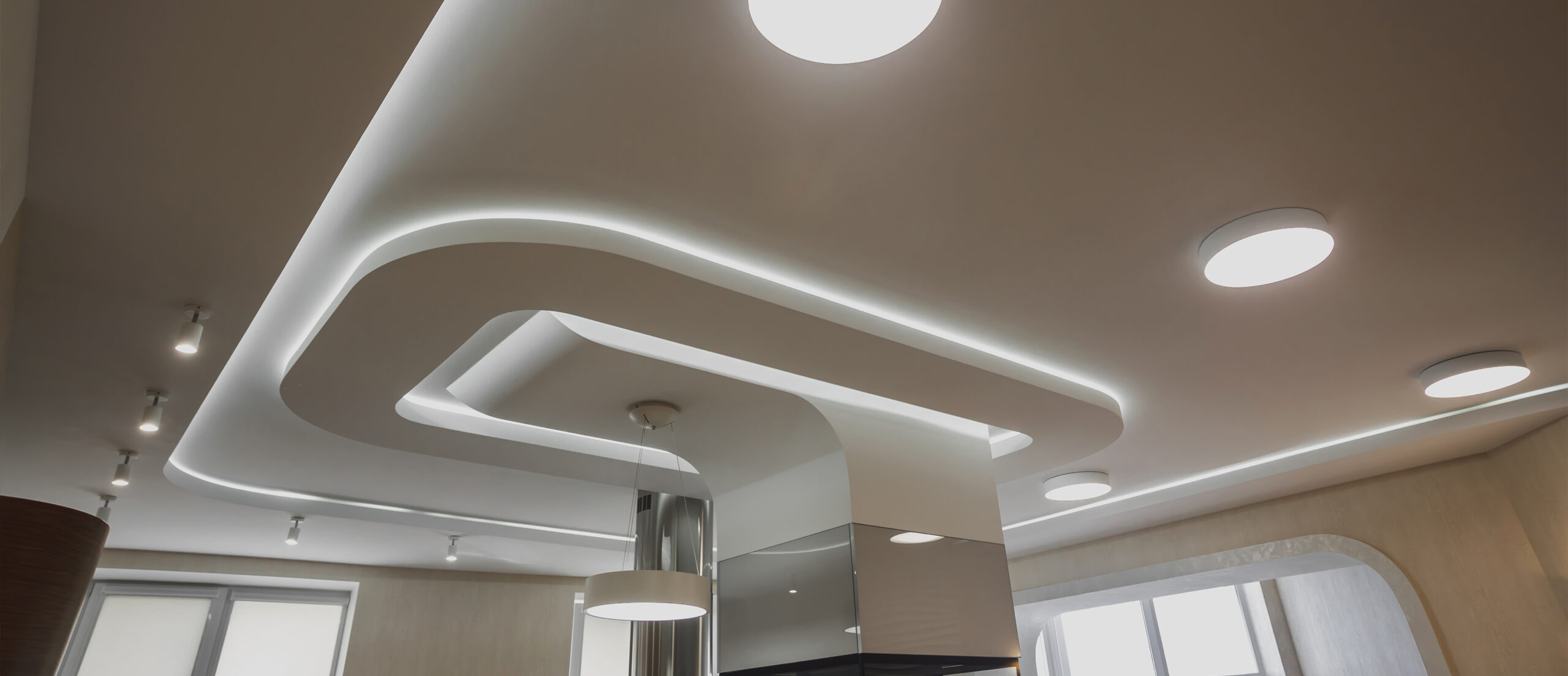 Woonkamerplafond met strakke lijnen en LED-strips voor sfeervolle verlichting, gerealiseerd door JRC Afbouw.
