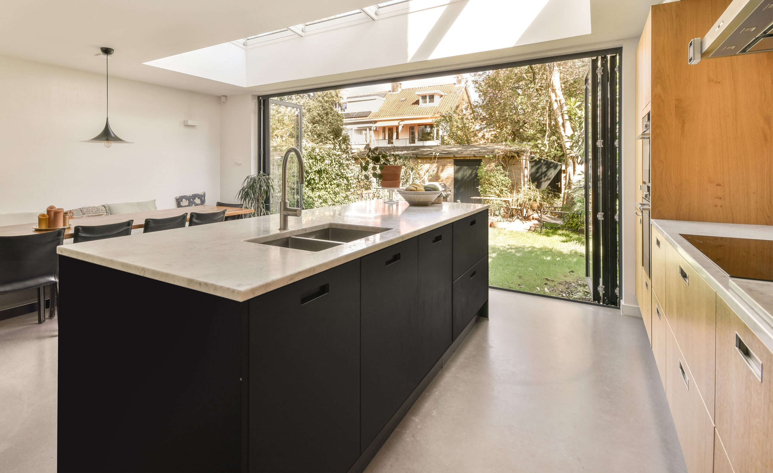 Moderne keuken met donker keukenblok, marmeren aanrechtblad en stijlvolle ingebouwde apparatuur, afgewerkt door JRC Afbouw.