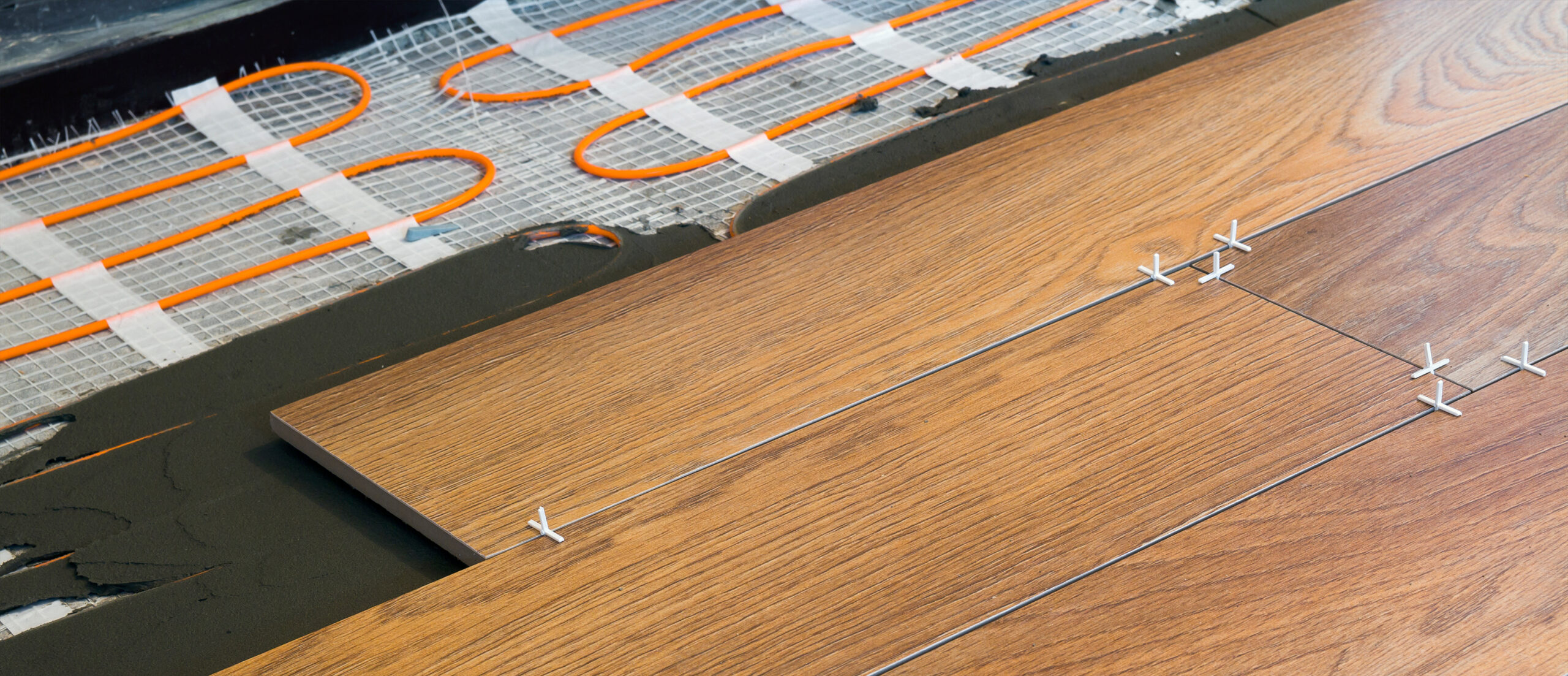 Elektrische vloerverwarming met houten vloerafwerking, professioneel geplaatst door JRC Afbouw voor optimaal wooncomfort.