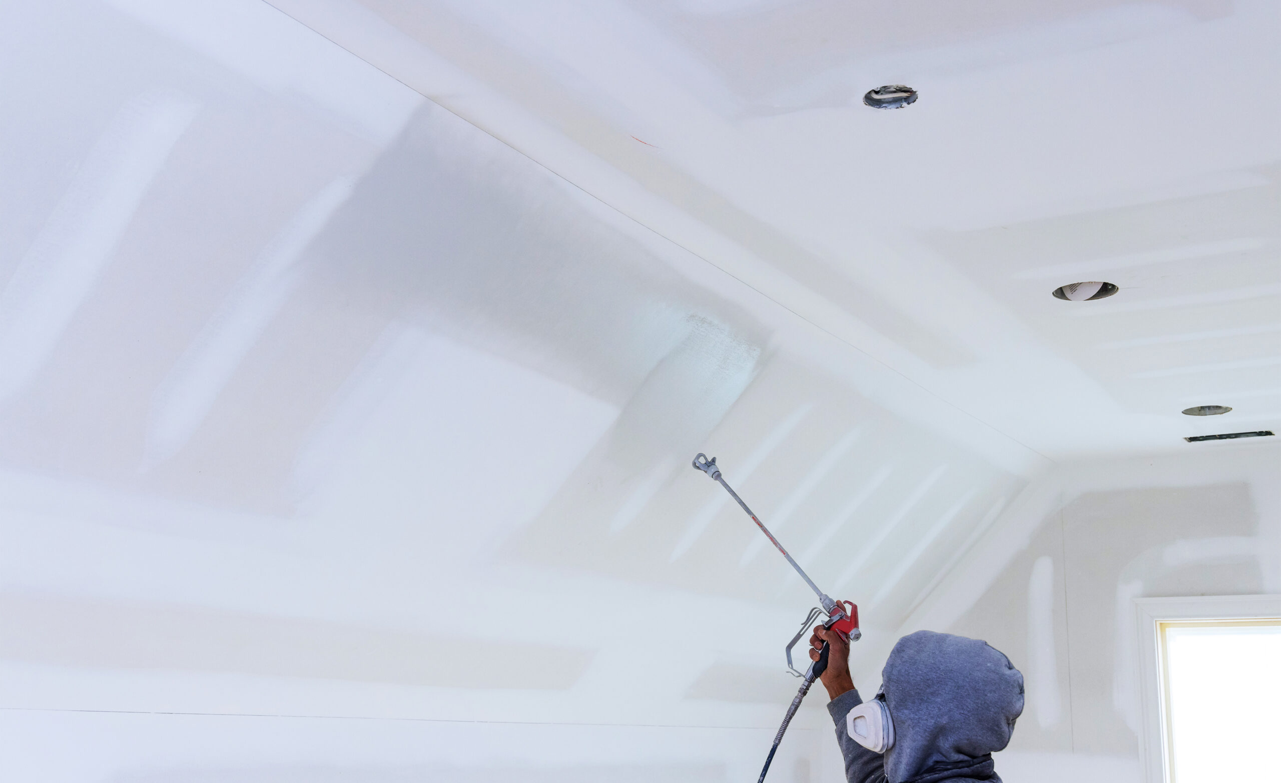 Professioneel spuitwerk aan het plafond door JRC, met een gladde afwerking en geïntegreerde plafondspots voor een strakke look